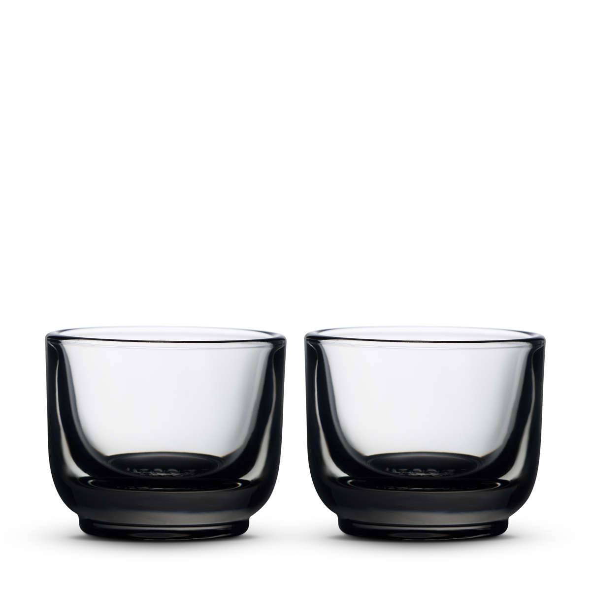 Two Fellow Pirch espresso glasses in smoke color on a plain white background.